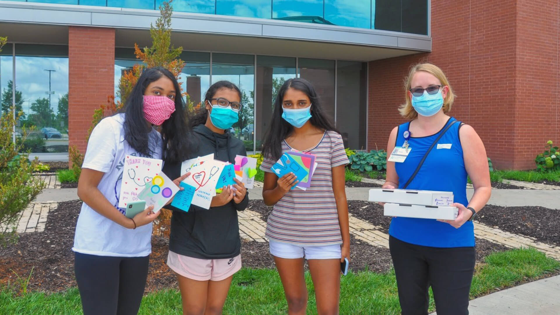 School Students Standing with MasteryConnect Leader wearing masks and smiling